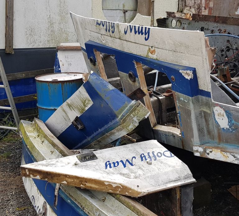 A broken-up GRP boat in a yard